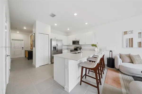 a kitchen with stainless steel appliances a refrigerator a sink a stove a microwave a counter top and cabinets