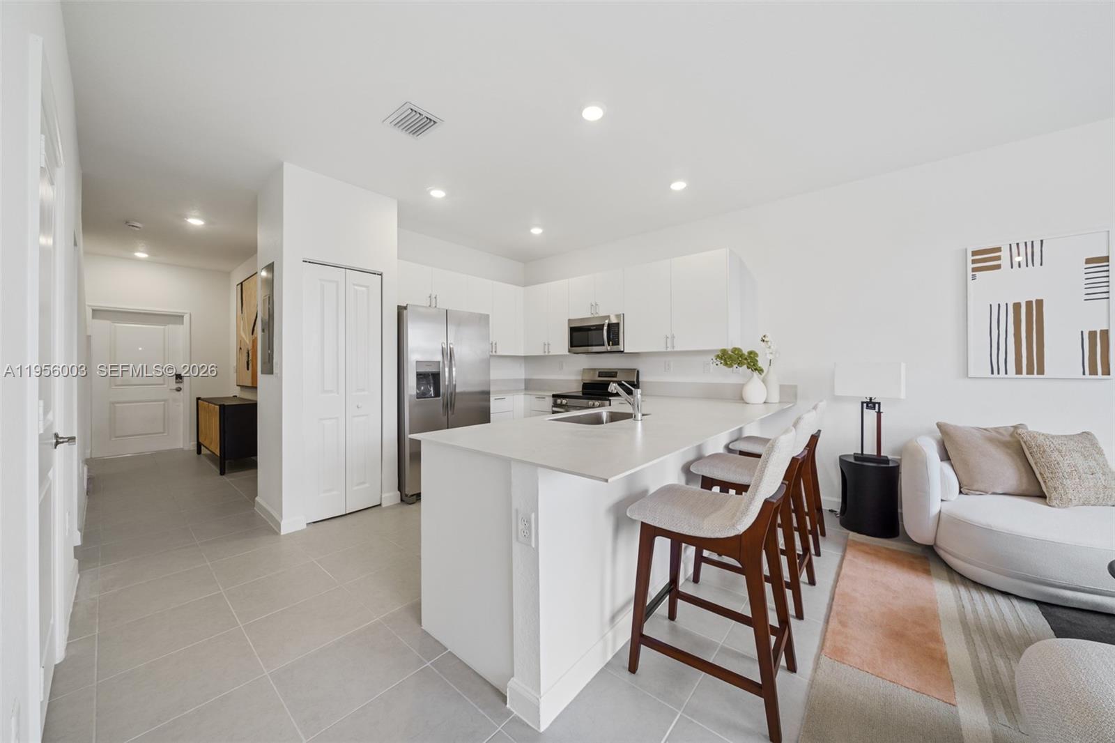 19448 Southwest 338th Terrace Homestead, FL 33034 - Photo 6 of 44 a kitchen with stainless steel appliances refrigerator dining table and chairs