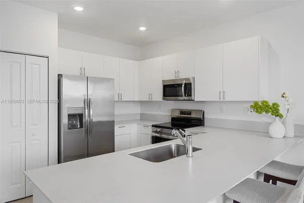 a kitchen with stainless steel appliances a stove a microwave a sink and cabinets