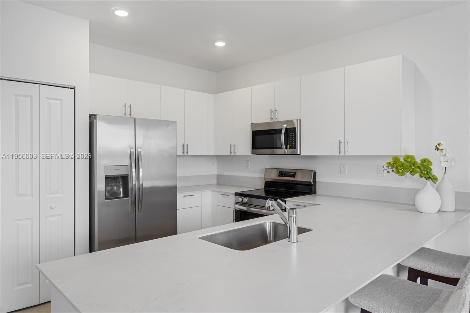 19448 Southwest 338th Terrace Homestead, FL 33034 - Photo 7 of 44 a kitchen with stainless steel appliances a refrigerator a sink a stove a microwave a counter top and cabinets