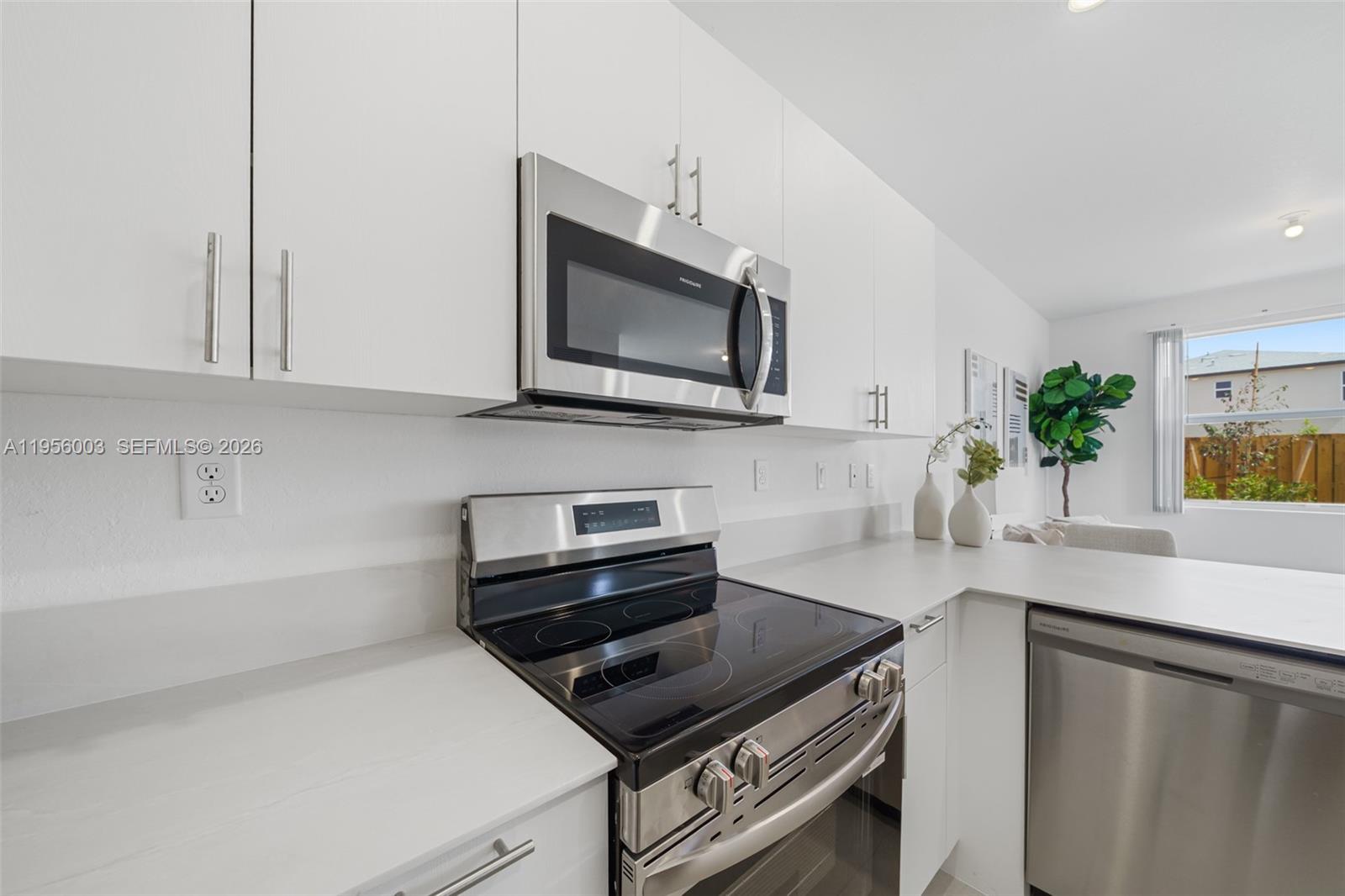 19448 Southwest 338th Terrace Homestead, FL 33034 - Photo 8 of 44 a kitchen with stainless steel appliances a stove a microwave a sink and cabinets