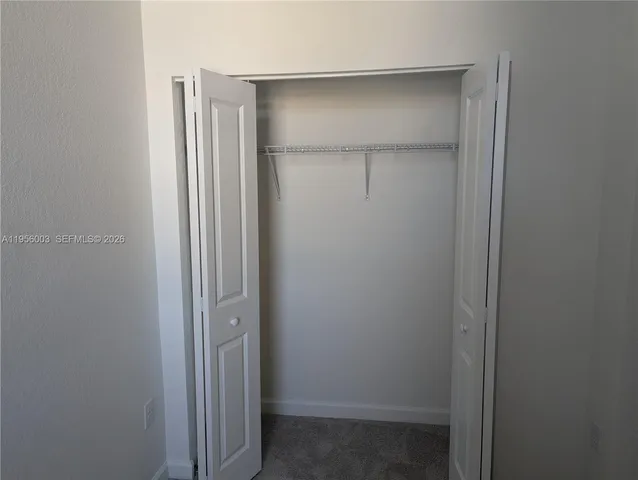 a view of walk in closet with empty racks