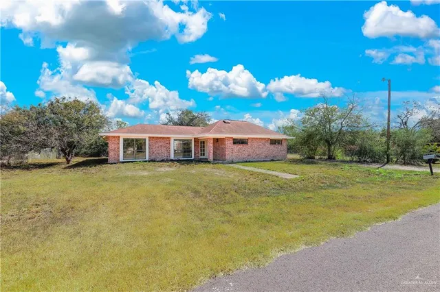 a front view of a house with a big yard