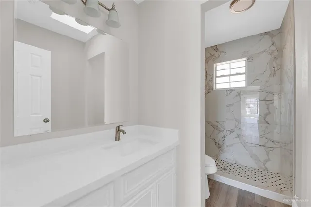 a bathroom with a sink a toilet and shower