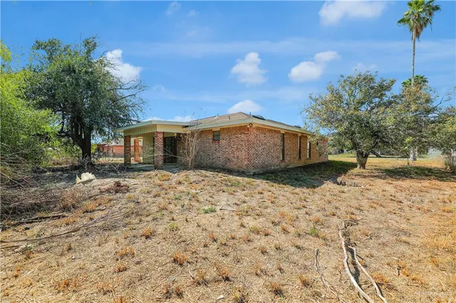 a view of a house with a yard and tree