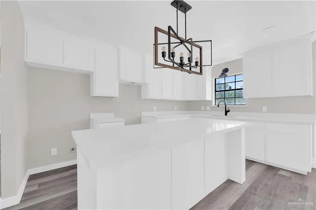 a kitchen with sink cabinets and wooden floor