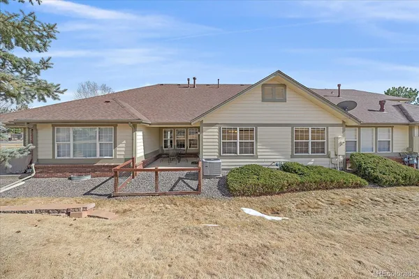 a front view of a house with a yard and potted plants