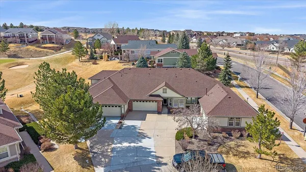 an aerial view of residential houses with outdoor space and trees