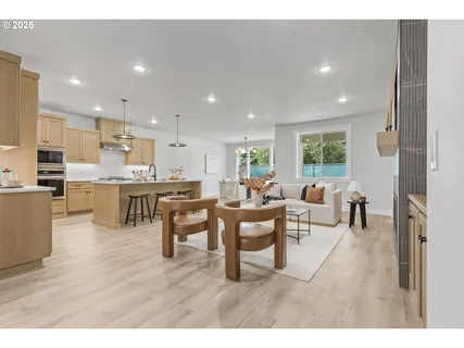 a living room with stainless steel appliances kitchen island granite countertop furniture and a wooden floor