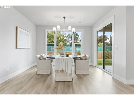 a living room with a large window and dining table