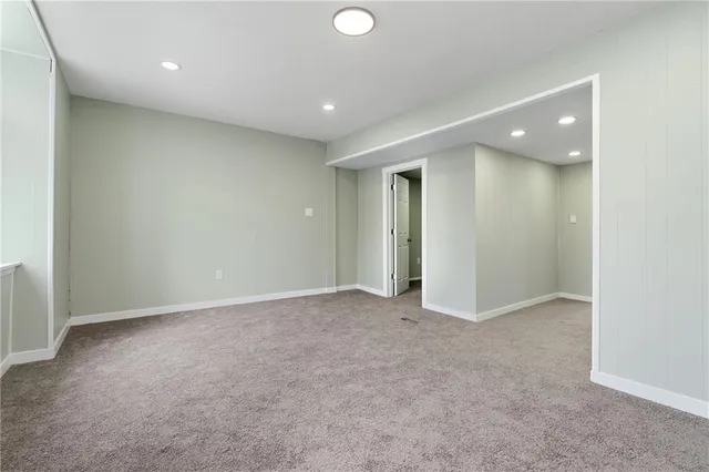 an empty room with windows and entrance to other room