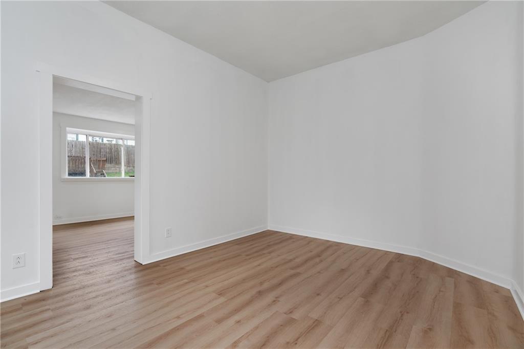 2307 Salisbury Street Pittsburgh, PA 15210 - Photo 5 of 24 an empty room with wooden floor and a window