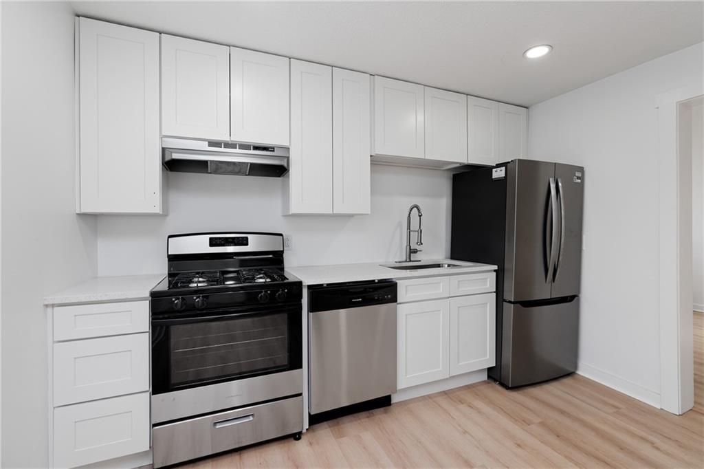 2307 Salisbury Street Pittsburgh, PA 15210 - Photo 7 of 24 a kitchen with a refrigerator stove and white cabinets