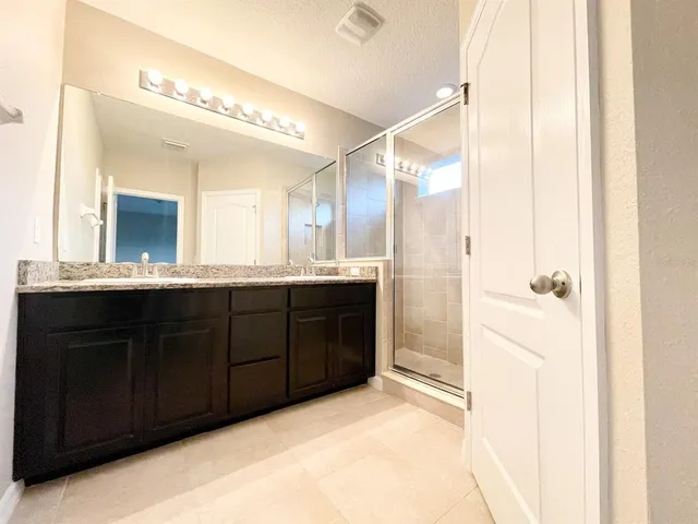 a bathroom with a double vanity sink and mirror with shower