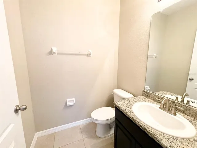 a bathroom with a granite countertop sink a toilet and a mirror