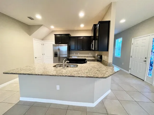 a large kitchen with a large counter top and stainless steel appliances
