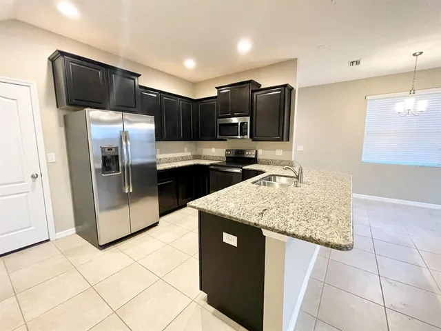a kitchen with stainless steel appliances granite countertop a refrigerator and a sink