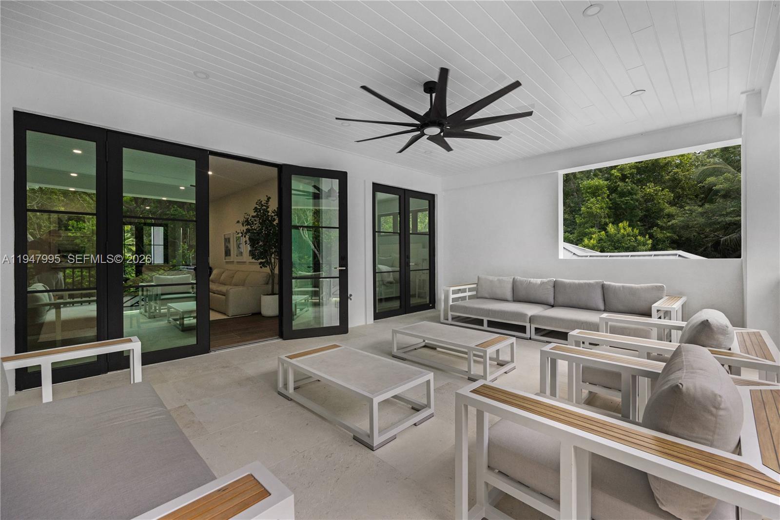 44 Card Sound Road Key Largo, FL 33037 - Photo 17 of 18 a living room with furniture a floor to ceiling window and a flat screen tv