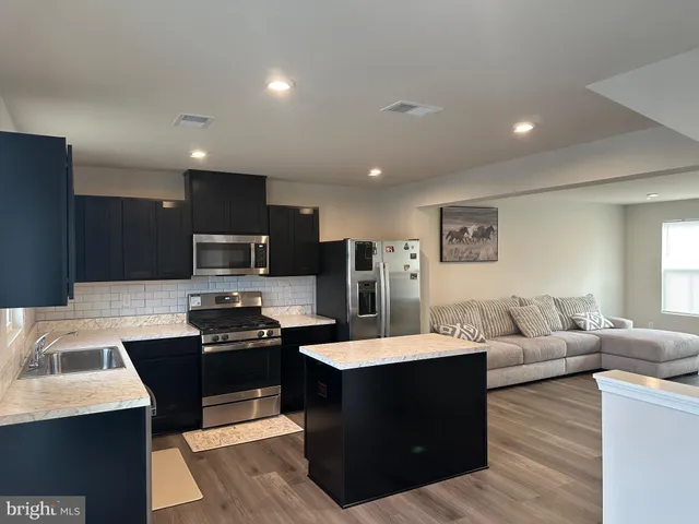 a large kitchen with a large counter top appliances and a couch