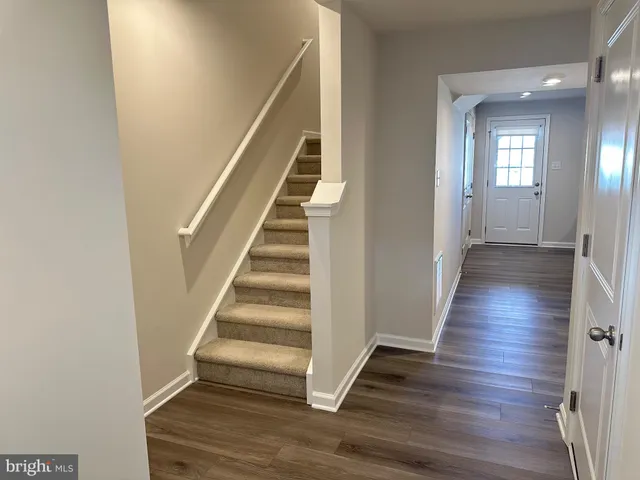 a view of a hallway with wooden floor and entryway