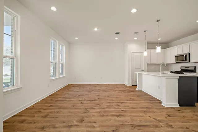 a open kitchen with kitchen island a sink dishwasher a stove and a refrigerator with wooden floor