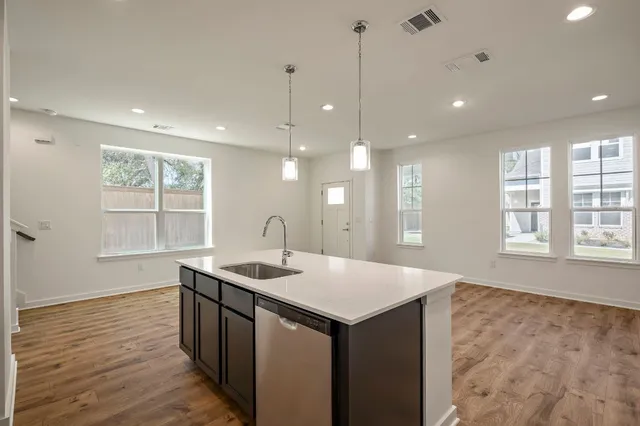 a kitchen with a sink a window and wooden floor