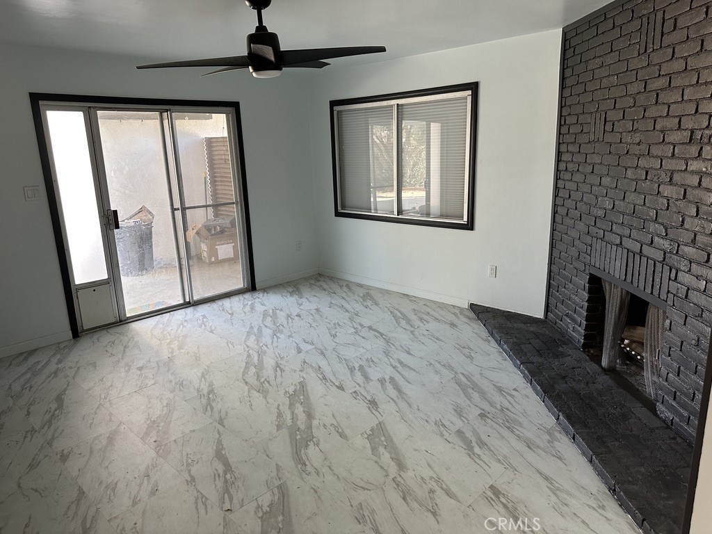 7428 Acoma Trail, Unit 2 Yucca Valley, CA 92284 - Photo 2 of 15 a view of an empty room with a fireplace and a window