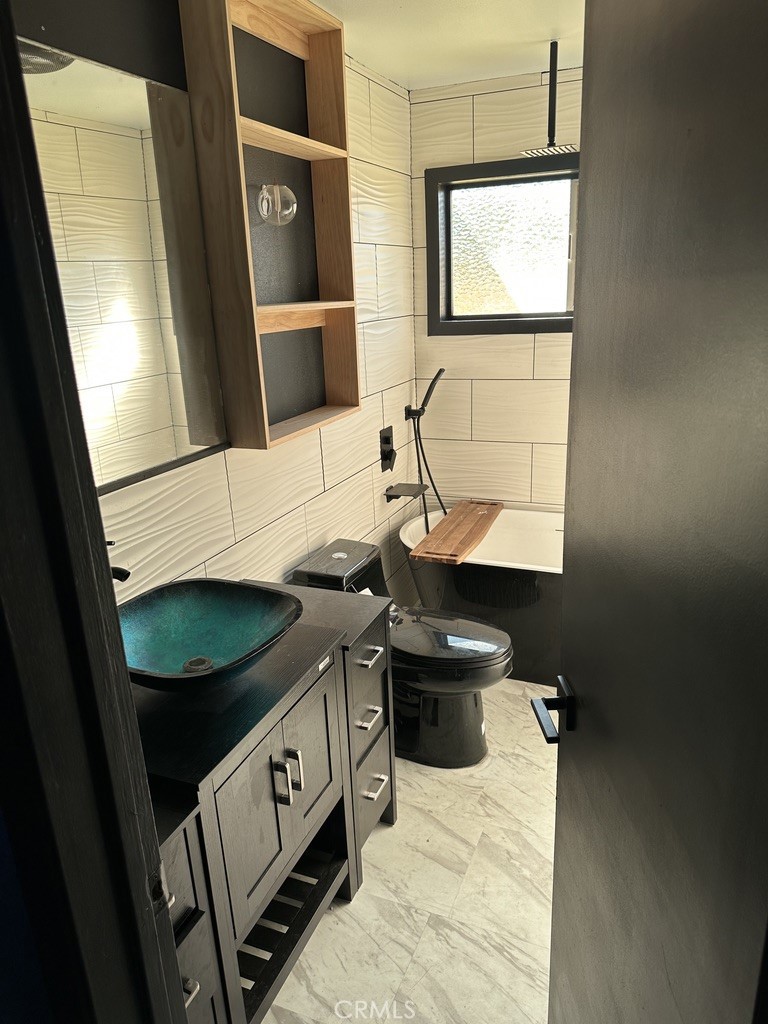 7428 Acoma Trail, Unit 2 Yucca Valley, CA 92284 - Photo 4 of 15 a bathroom with a sink a toilet and mirror