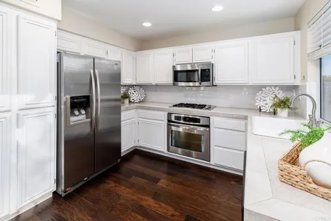 a kitchen with stainless steel appliances a refrigerator sink and microwave