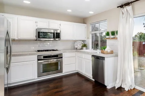 a kitchen with stainless steel appliances a stove a sink and a microwave