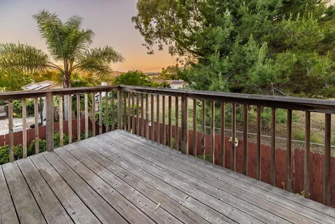 a balcony with wooden floor and fence