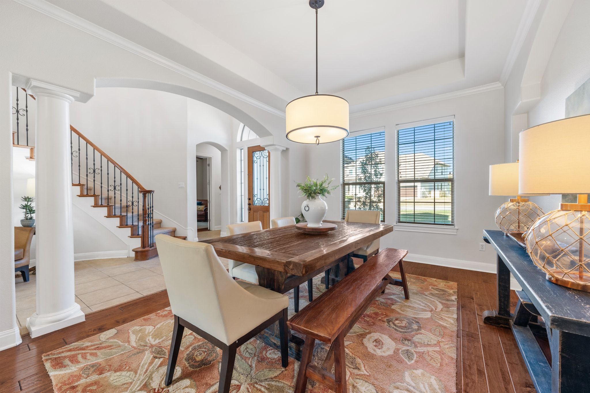 15201 Bat Hawk Circle Austin, TX 78738 - Photo 5 of 33 a dining room with wooden floor a chandelier a wooden table and chairs