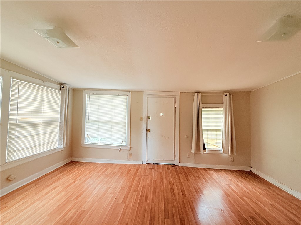 809 Cook, Unit A&B Odem, TX 78370 - Photo 2 of 12 an empty room with wooden floor and windows