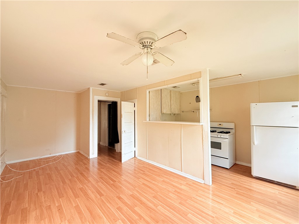 809 Cook, Unit A&B Odem, TX 78370 - Photo 7 of 12 a view of a kitchen with wooden floor and a ceiling fan