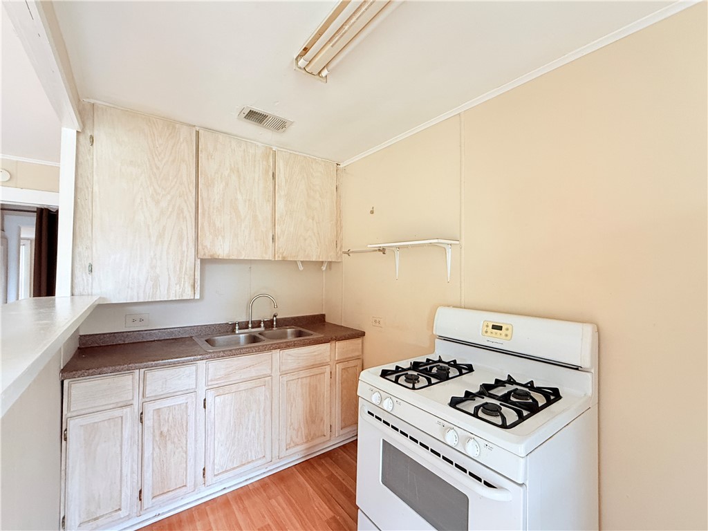 809 Cook, Unit A&B Odem, TX 78370 - Photo 9 of 12 a kitchen with white cabinets stove top oven and sink