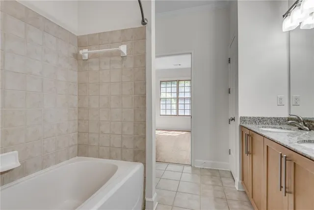 a bathroom with a granite countertop bathtub shower and toilet