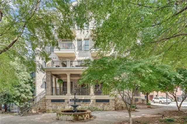 a front view of a house with trees and plants