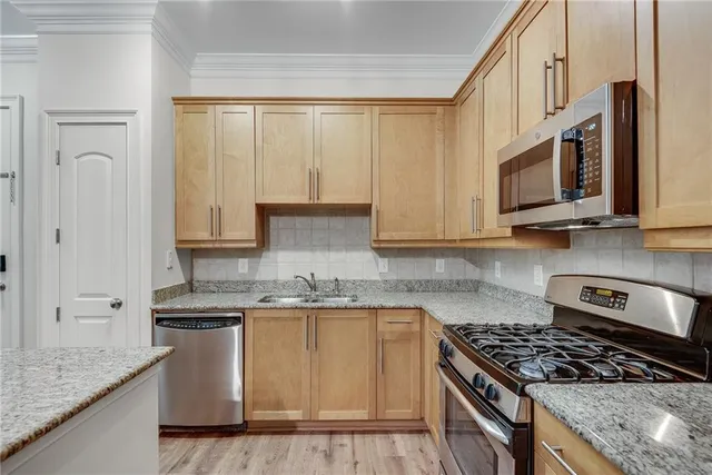 a kitchen with stainless steel appliances granite countertop a stove a sink and a microwave