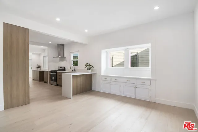 a large kitchen with stainless steel appliances lots of counter space and windows