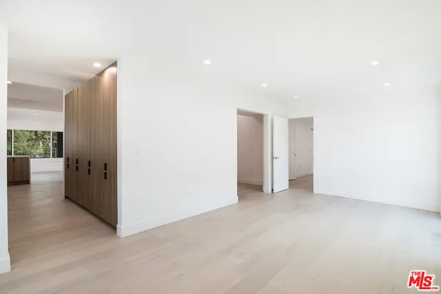 a view of a big room with wooden floor and windows