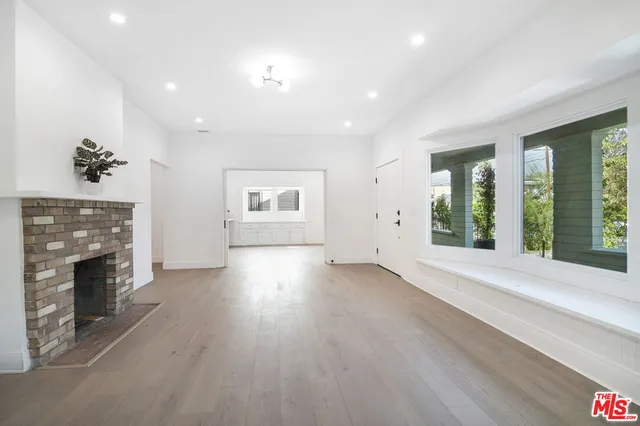 an empty room with windows fireplace and windows