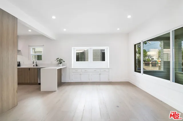 a view of a room with a kitchen and wooden floor