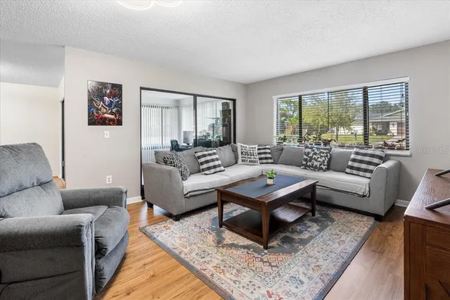 a bed sitting in a bedroom next to a window with bookshelf