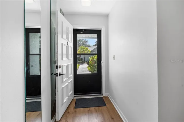 a view of a hallway with wooden floor windows and livingroom