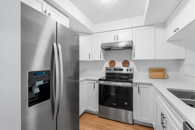 a kitchen with stainless steel appliances a refrigerator a sink and a stove