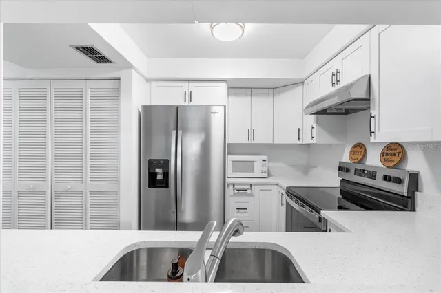 a kitchen with a table chairs sink and cabinets