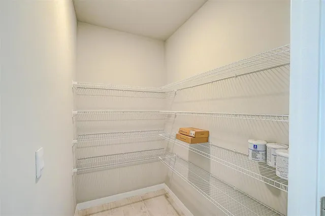 an empty room with a window and a kitchen