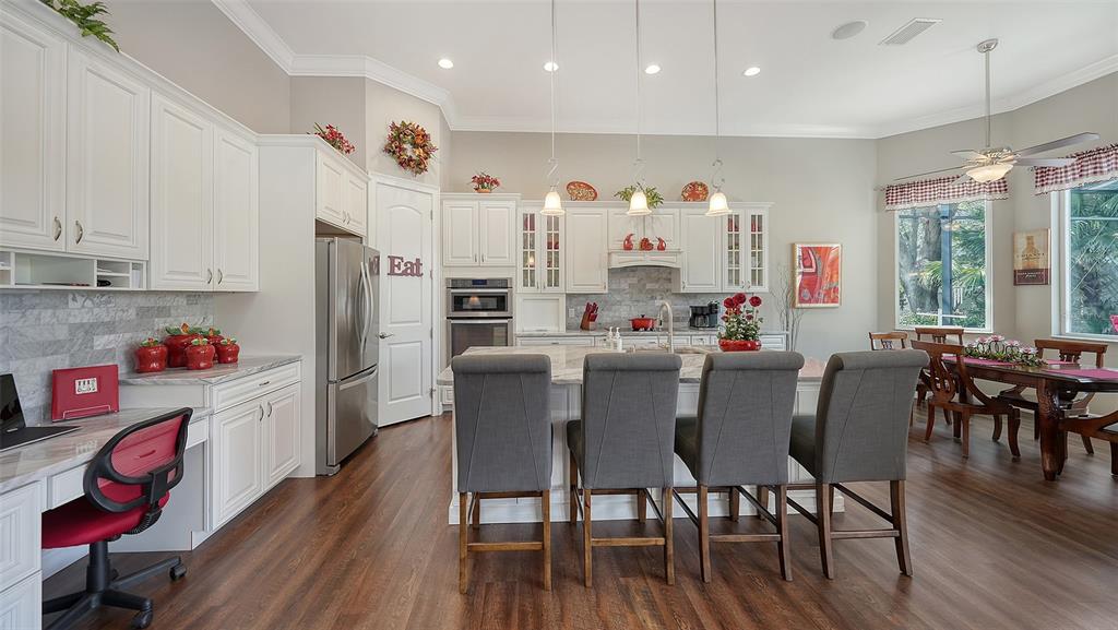 20 Bayhead Lane Osprey, FL 34229 - Photo 12 of 72 a kitchen with stainless steel appliances kitchen island granite countertop a dining table chairs refrigerator and sink