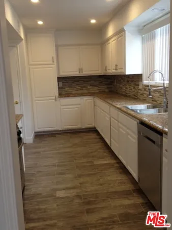 a kitchen with granite countertop a sink and cabinets