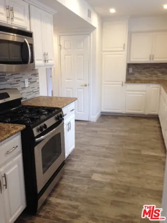 a kitchen with granite countertop a sink and a stove top oven